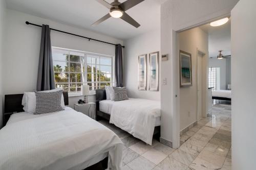 1 dormitorio con 2 camas y ventana en Best Location SOBE Top Floor 2 min to beach & fun, en Miami Beach