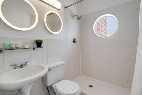 y baño con lavamanos y 2 espejos. en Best Location SOBE Top Floor 2 min to beach & fun, en Miami Beach