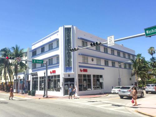 a white building on a street corner with people crossing the street at Best Location SOBE Top Floor 2 min to beach & fun in Miami Beach