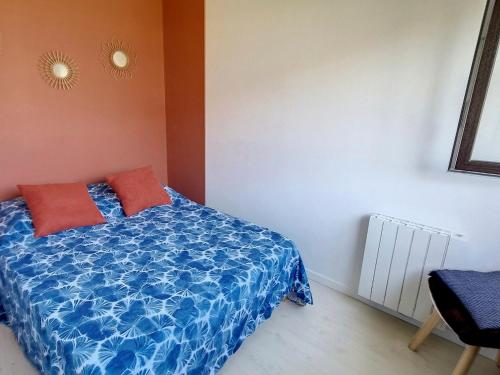 - une chambre avec un lit bleu et des oreillers rouges dans l'établissement Charmant appartement 4 couchages à 500m de la mer, parking inclus - Courseulles-sur-Mer - FR-1-746-15, à Courseulles-sur-Mer