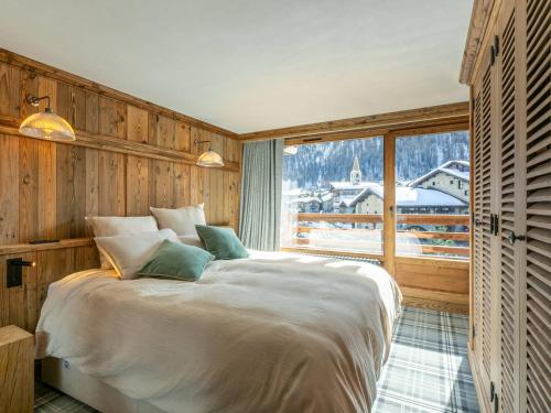 una camera da letto con un letto grande e una grande finestra di Luxueux appartement 5 pièces avec balcons et vues, proche pistes - FR-1-694-354 a Val dʼIsère