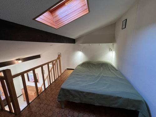 Cet appartement comprend une chambre dotée d'un lit et d'une lucarne. dans l'établissement Villa T2 mezzanine climatisée avec piscine, proche plage - La Franqui - FR-1-81-608, à La Franqui-Plage