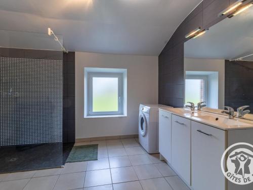 une salle de bain avec un lavabo et une machine à laver dans l'établissement Gîte de charme avec terrasse, près de Nantes, campagne des Mauges, idéal pour familles et pêcheurs - FR-1-622-73, à La Jactrie