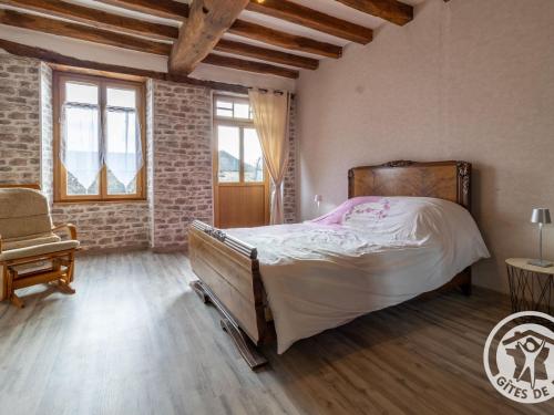 une chambre avec un grand lit et une chaise dans l'établissement Gîte de charme avec terrasse, près de Nantes, campagne des Mauges, idéal pour familles et pêcheurs - FR-1-622-73, à La Jactrie