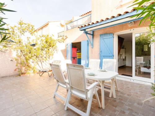 une table blanche et des chaises sur une terrasse dans l'établissement Pavillon climatisé 4 pièces avec WIFI, proche plage, terrasse, barbecue, park. privatif, animaux admis - FR-1-409-249, à Gruissan