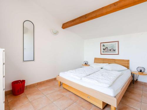 une chambre avec un lit dans une pièce blanche dans l'établissement Pavillon climatisé 4 pièces avec WIFI, proche plage, terrasse, barbecue, park. privatif, animaux admis - FR-1-409-249, à Gruissan