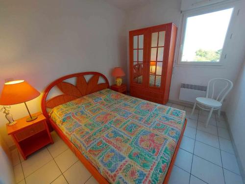 une chambre avec un lit, une lampe et une fenêtre dans l'établissement Appartement 3 pièces en bord de mer avec terrasse et parking, 6 personnes - FR-1-423-293, au Grau-dʼAgde