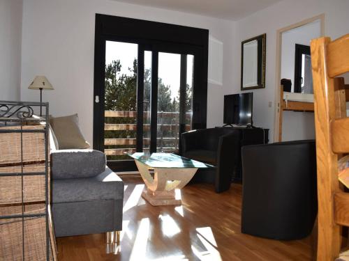 uma sala de estar com um sofá e uma mesa em Appartement Bolquère-Pyrénées 2000, 2 pièces, 4 personnes - FR-1-592-69 em Font Romeu Odeillo Via