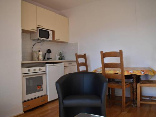 uma cozinha com uma mesa e 2 cadeiras e uma mesa e uma cadeira em Appartement Bolquère-Pyrénées 2000, 2 pièces, 4 personnes - FR-1-592-69 em Font Romeu Odeillo Via