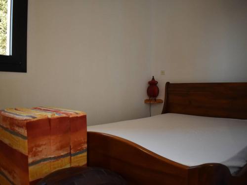 um quarto com uma cama e um vaso vermelho numa prateleira em Appartement Bolquère-Pyrénées 2000, 2 pièces, 4 personnes - FR-1-592-69 em Font Romeu Odeillo Via