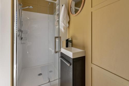 a bathroom with a shower and a sink at Valley View - Whangarei Tiny Home in Whangarei