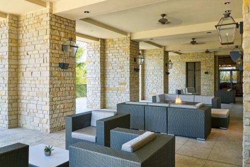 a lobby with chairs and tables and brick walls at The Westin Dallas Stonebriar Golf Resort & Spa in Frisco