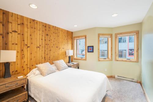 a bedroom with a white bed and wooden walls at Lulu City 6K by AvantStay Condo in Great Location Close to Skiing Downtown in Telluride