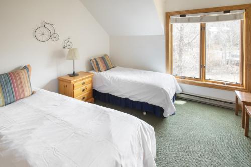 a bedroom with two beds and a window at Cimarron Lodge 7 by AvantStay Ski-InSki-Out Property in Complex w Two Hot Tubs in Telluride