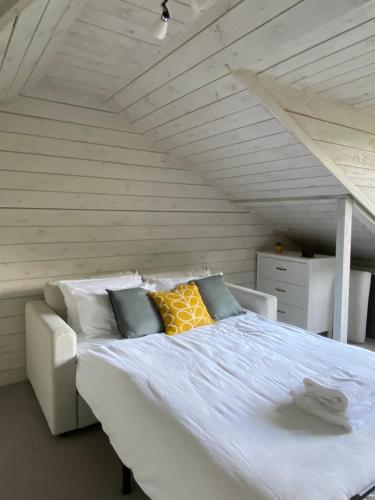 uma cama branca com almofadas num quarto em Grand Victorian family home - nestled between woodland and beach em Haven Street