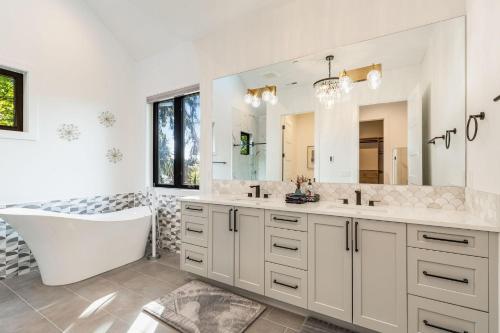 a bathroom with a tub and a large mirror at Bellevue Splendor Birch Cedar Suite BY Betterstay in Bellevue