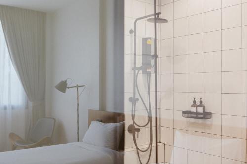 a shower in a hotel room with a bed at Karpenter Lampang in Lampang