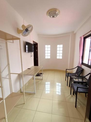 a living room with a table and chairs at เอส ที อพาร์ทโฮเทล / S.T.ApartHotel in Ban Khao Rup Chang
