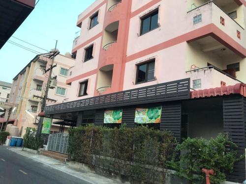a pink building on the side of a street at เอส ที อพาร์ทโฮเทล / S.T.ApartHotel in Ban Khao Rup Chang
