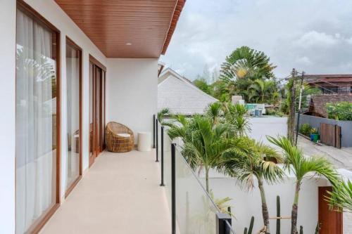 a balcony with palm trees in a house at New Cozy 2-b Villa in Canggu in Munggu
