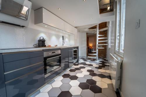 - une cuisine avec un sol en damier noir et blanc dans l'établissement Pargaminières by Yumē, à Toulouse