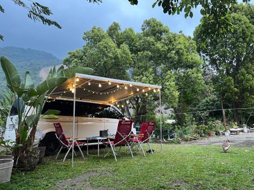 a group of chairs and a table under a tent at Niuniu & Meng Ka Homestay in Liugui