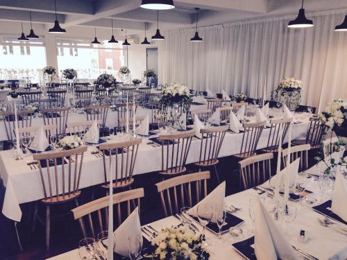 a large banquet hall with tables and chairs with flowers at Fugl Fønix Hotel in Etnesjøen