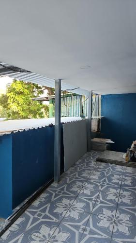 Habitación con pared azul y suelo de baldosa. en Estadia Regalo de Dios, 