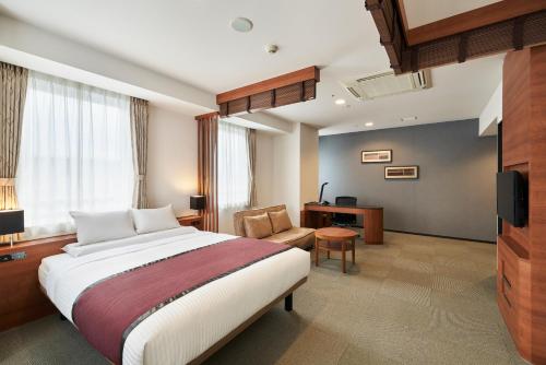 Pokój hotelowy z dużym łóżkiem i krzesłem w obiekcie MYSTAYS Shin Urayasu Conference Center w mieście Urayasu