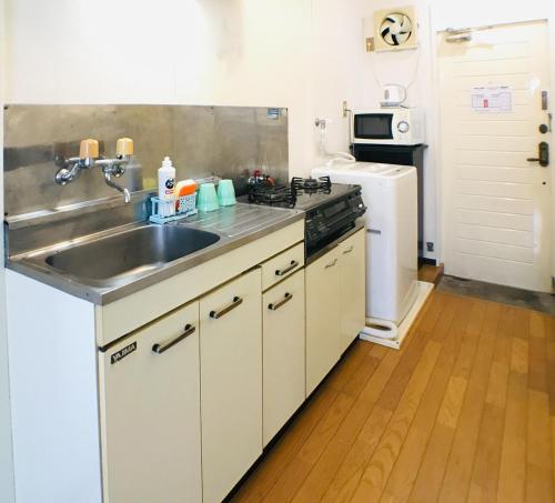 a kitchen with a sink and a stove at Best Room In Kawagoe 3 in Kawagoe