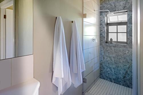 a bathroom with a shower and a white towel at Belvidere Manor Lagoonside Cottages in Knysna