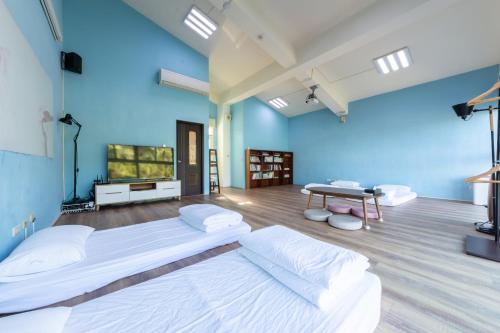 a large room with two beds and a television at 光腳丫宜蘭民宿 in Dongshan
