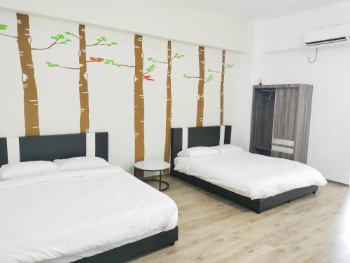 two beds in a room with trees on the wall at 彬彬流星瞭望台 The VenusBlock B 31st floor Sri Manjung in Seri Manjung