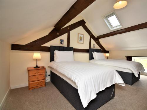 two beds in a attic bedroom with a roof at 2 Bed in Rhayader 45387 in Llangurig
