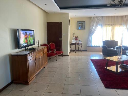 a living room with a tv on a wooden dresser at AEROPARK RESIDENCIAL2 in Maputo