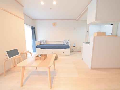 Sala de estar con cama y mesa en Residence Hotel Kamoike, en Kagoshima