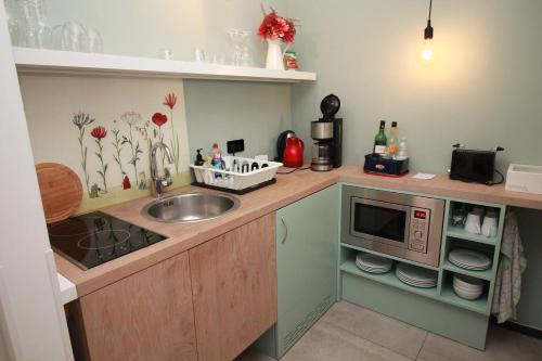 een keuken met een wastafel en een magnetron bij Fewo-Suite "Horizonte I"mit Boot in Ascheberg