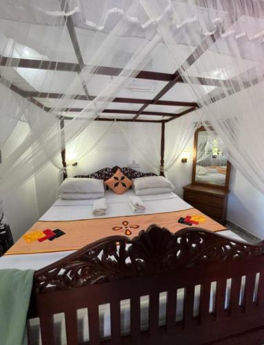a bedroom with a large bed with a net at Lucky Prince Villa in Aluthgama