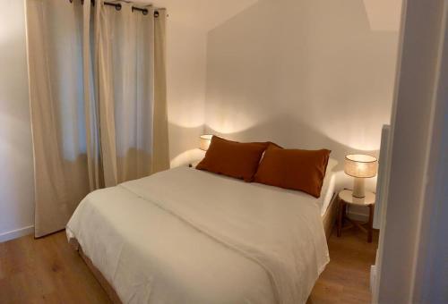- une chambre avec un lit blanc et 2 oreillers dans l'établissement Petite maison cocooning à Bormes les mimosas, à Bormes-les-Mimosas