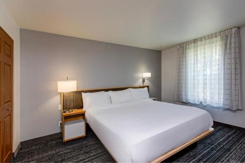 a bedroom with a large white bed and a window at TownePlace Suites Denver Southwest/Littleton in Littleton