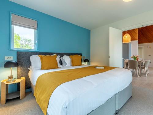 1 dormitorio con 1 cama grande y pared azul en 3 Bed in St. Mellion 87719, en St Mellion