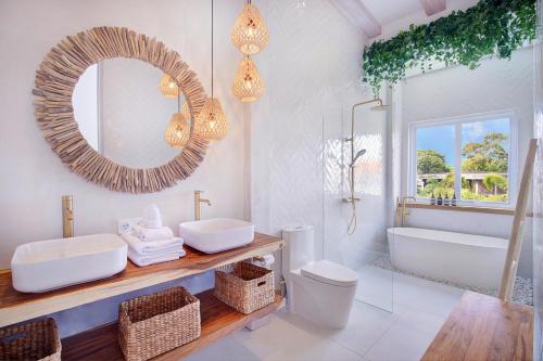 La salle de bains est pourvue d'une baignoire, d'un lavabo et d'un miroir. dans l'établissement Matanai Villas, à Canggu