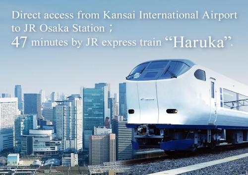 a white train on tracks in front of a city at Hotel Vischio Osaka-JR Hotel Group in Osaka