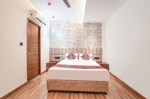 a bedroom with a bed and a brick wall at FabHotel The Comfort Inn in Kānpur