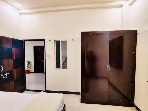 a bedroom with a bed and a large wooden door at DivineStay - Full Villa by AP Villas in Ujjain