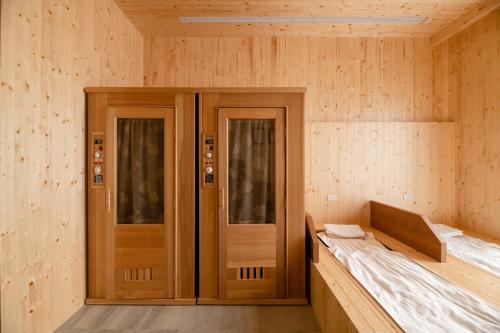 a wooden room with two doors and a bed in it at In Joy Hotel in Taichung