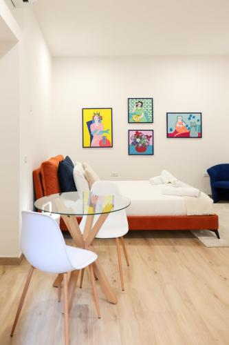 a bedroom with a bed and a table and chairs at Sorelle Costa apartments in Caserta