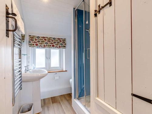 Great Longstone的住宿－2 Bed in Ashford-In-The-Water 85314，一间带水槽和玻璃淋浴的浴室