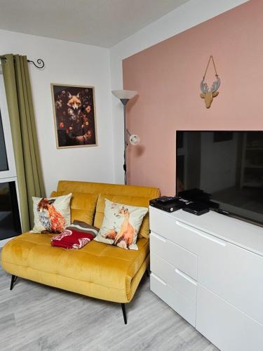 a living room with a couch and a flat screen tv at Thüringer Panorama in Gossel