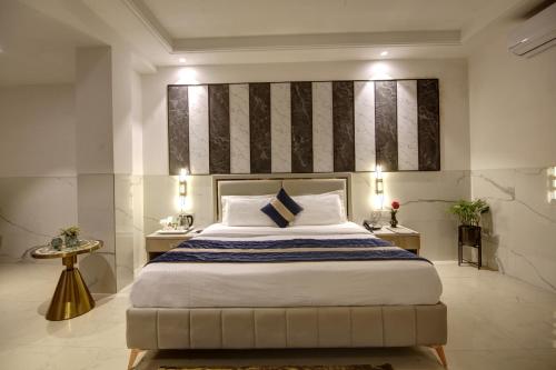 um quarto com uma cama grande e duas mesas em Hotel Delhi 37 by Star Group NEAR DELHI AIRPORT em Nova Deli